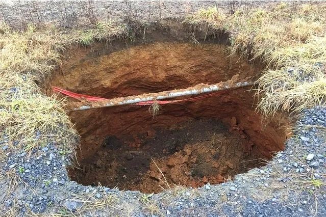 Open sinkhole repair with exposed pipe