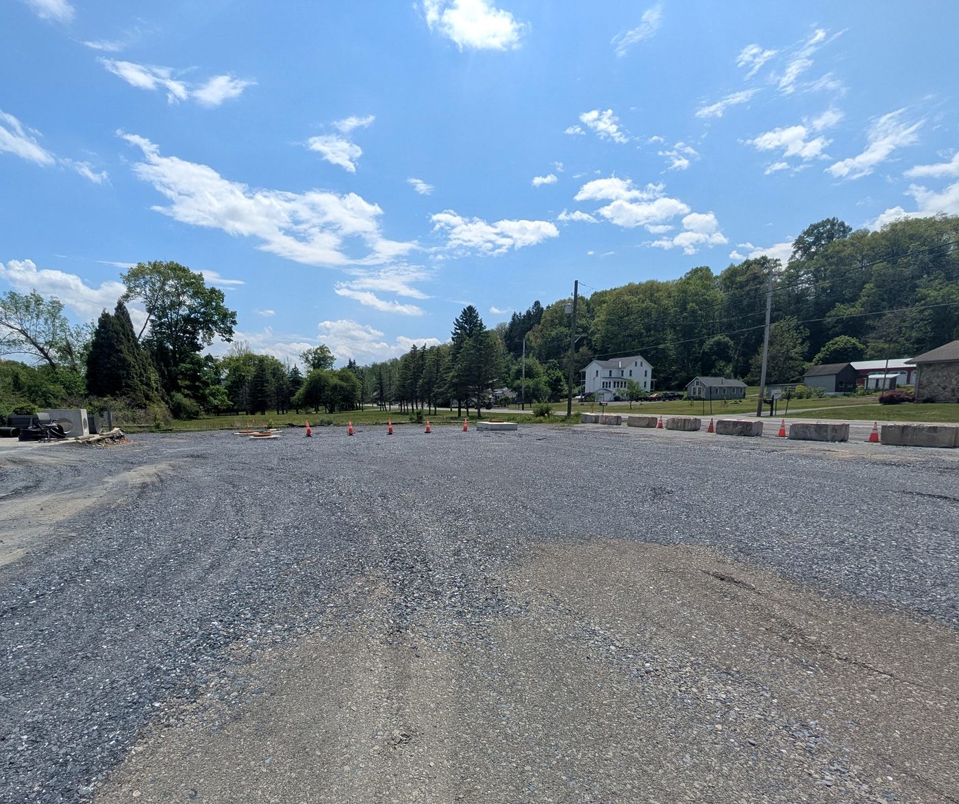 Fresh stone base pad compacted and ready for paving under a blue sky