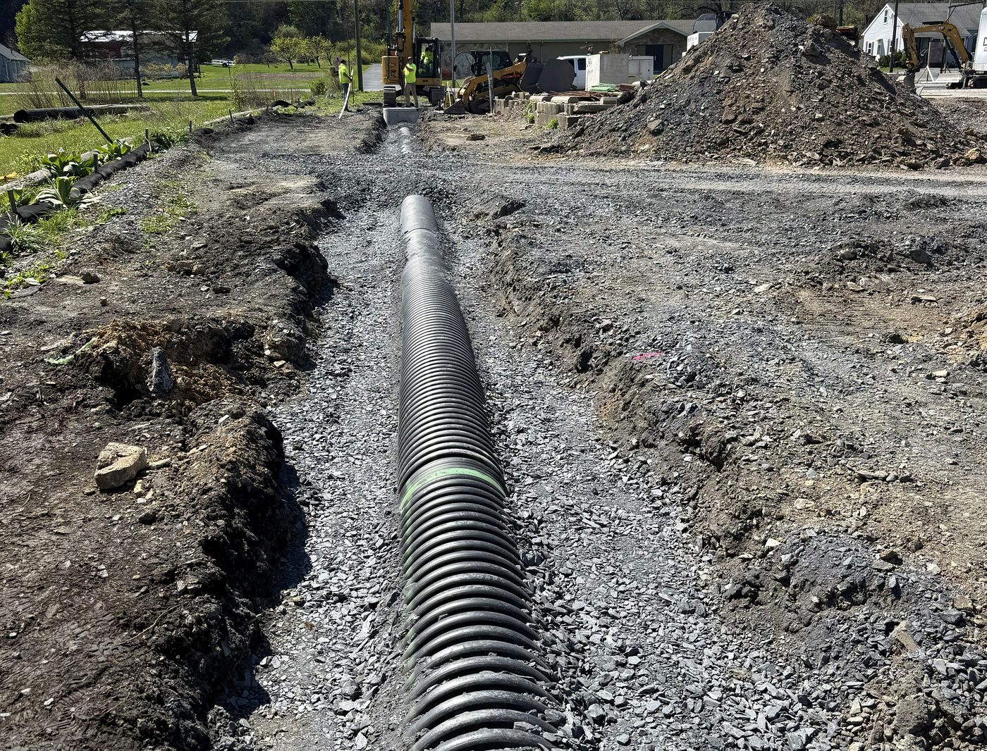 Corrugated drainage pipe laid on stone bedding in an open trench